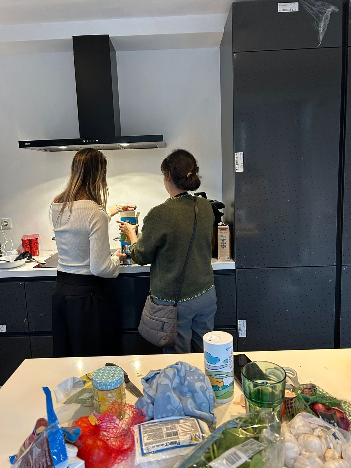 Two guests cooking side by side at the hob during a Curry Studio workshop