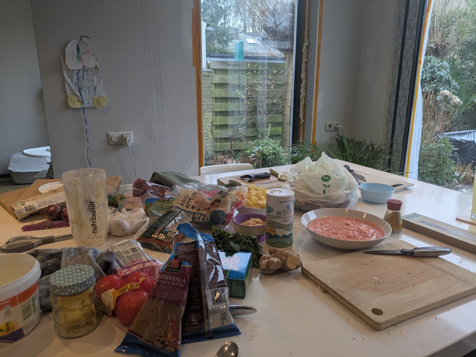 A home kitchen table covered in the ingredients laid out at the start of a Curry Studio cooking workshop