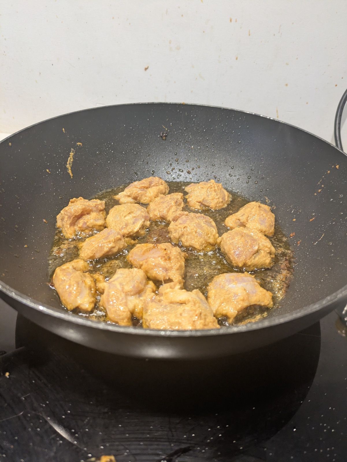 Marinated chicken frying in a wok during a Curry Studio cooking workshop