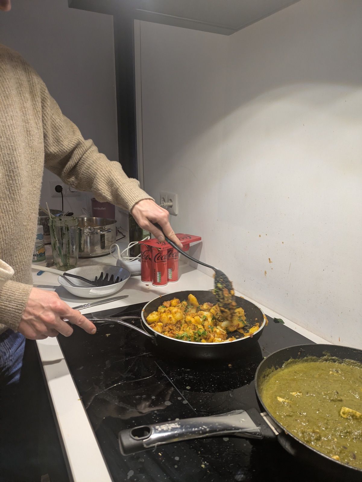 Two pans of freshly cooked curry being finished at the end of a Curry Studio workshop